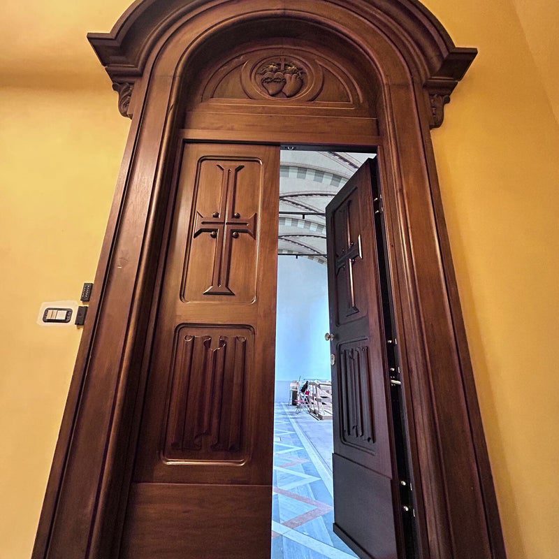 Porta blindata a due ante intagliata, aperta, in un palazzo d'epoca: lo stile adatto ai borghi storici di Chivasso