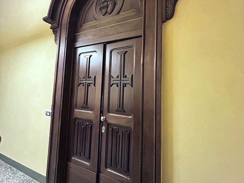Porta blindata a due ante con pannelli intagliati in un palazzo d'epoca, soluzione adatta al centro storico di Chieri